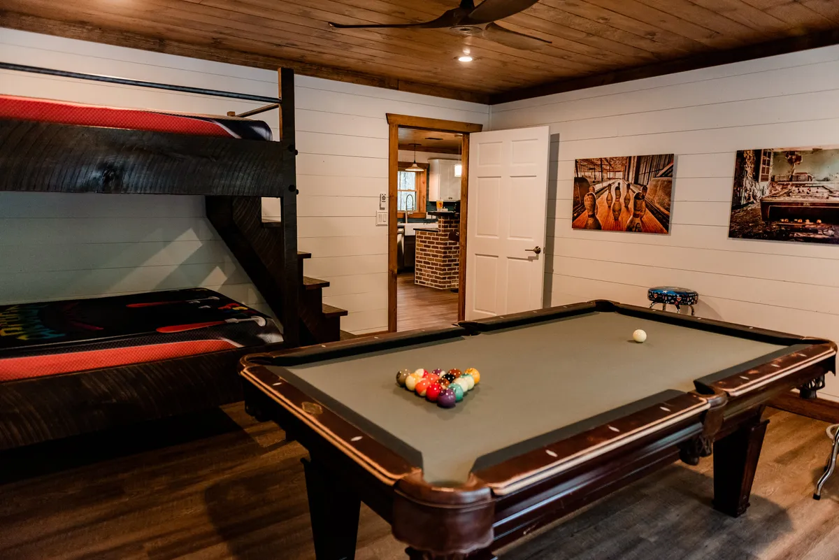 Inside, this playful space combines a pool table, bunk bed, and creative wall art, balancing entertainment and comfort. The scene hints at friendly competition, sleepovers, and relaxed evenings, perfectly reflecting the described flexibility and fun for all ages.